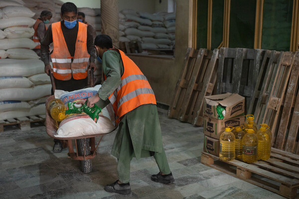 Wheelbarrows are loaded with oil, salt, flour and lentils at a WFP distribution center in Kabul.