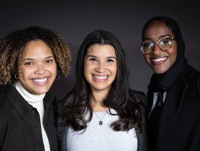 Three Black women smile for a posed photo