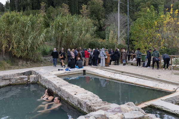 A group of tourists walk to the archaeological site at San Casciano dei Bagni, located next to a public thermal water pool, on Nov. 12.
