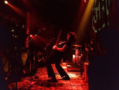 Side view of guitarist playing while dramatically leaning back