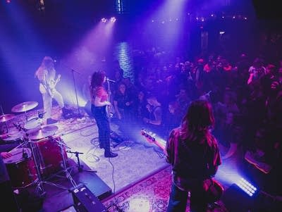 View from above of the backs of the band and a crowd watching them