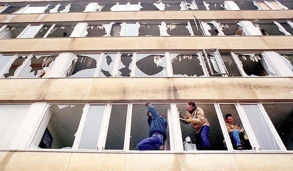 Workers remove broken glass in a Gustavus Adolphus residence hall.
