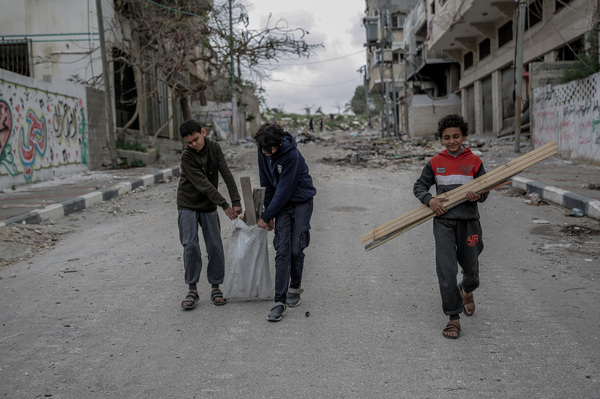 Yousef Tafesh (center), 14, with his brothers near their home in Hayy al-Nasr. The boys go out every day in search of pieces of wood to warm the house and cook food, since Israel cut off fuel and electricity to the Gaza Strip.