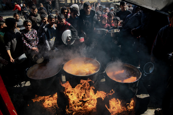 Palestinians gather to receive soup at one of the few soup kitchens in northern Gaza, on Feb. 26. These days, soup kitchens can offer only watery lentil soup or boiled carrot soup, as food dwindles.