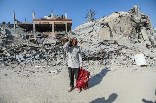 People inspect damage and remove items from their homes following Israeli airstrikes on April 7, in Khan Yunis, Gaza.