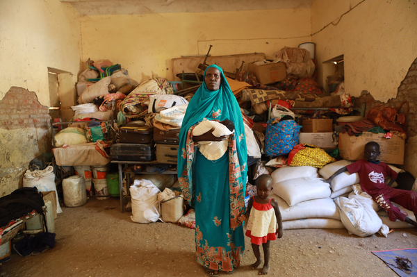 Mary Monga was forced to flee her home in Khartoum with her children. She posed for a portrait on Dec. 10, 2023. She says, "My baby is only 1 month old, but he looks younger because of the weight of the baby. When I think about the future, I want my child to have an education."