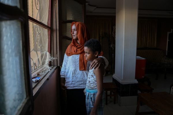 A woman and her son with autism look out at Port Sudan in the Red Sea state. She said that she wants to explain to him that the war was lost.