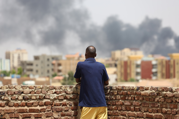 A man looks at the smoke rising next to the Army General Command in Khartoum, Sudan, on April 16, 2023.