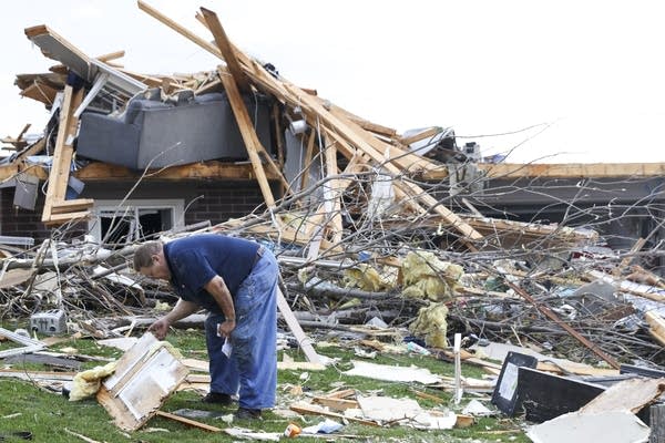 Man looks at damaged house