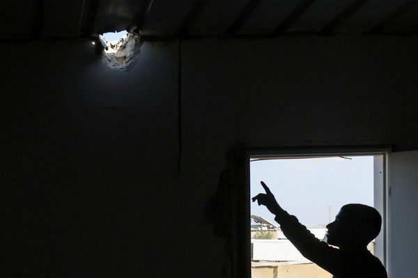 A relative points to a hole in the roof of Mohammed al-Hassouni's family home. It was caused by an Iranian missile fragment that injured his 7-year-old daughter on the night Iran attacked Israel.