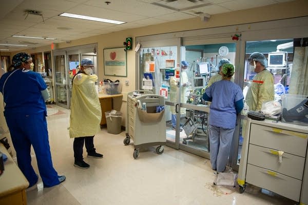 People wearing PPE in a hospital hallway.