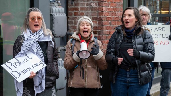 Valerie Costa, on the right, joins other Tesla Takedown protesters demonstrating at a carmaker facility in the Seattle area in early March.