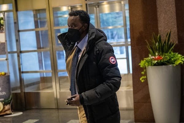 A masked person walks into a court building