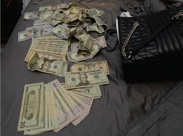 cash spread out next to Gucci handbag