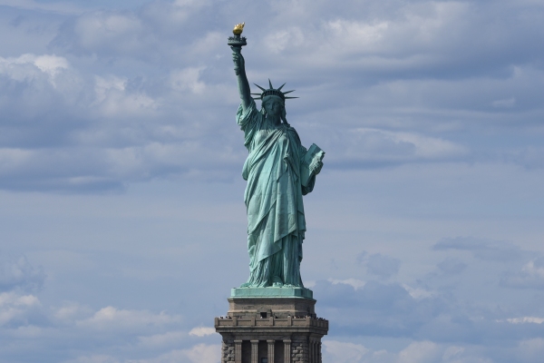 The Statue of Liberty pictured against a blue sky.