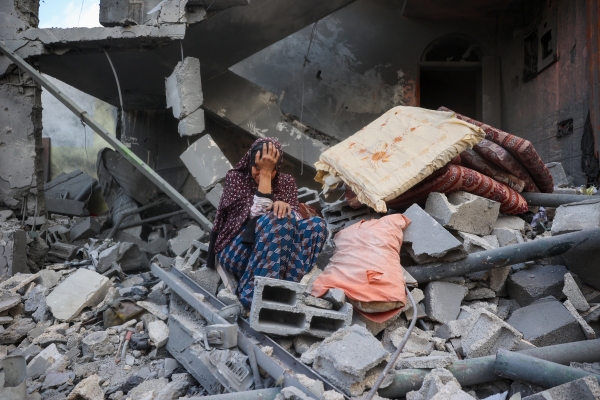 A woman cries while sitting on the rubble of her house, destroyed in an Israeli strike, in the Nuseirat refugee camp in central Gaza Strip on Tuesday. Israel on Tuesday unleashed its most intense strikes on the Gaza Strip since a January ceasefire.