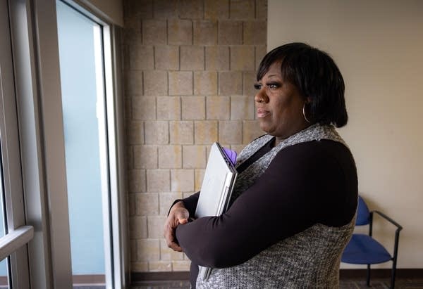 A woman looks through a doorway.