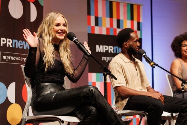 A woman talks and raises her hands