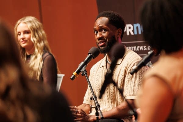 A man talks into a microphone 