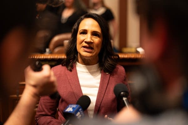 A woman talks to the press