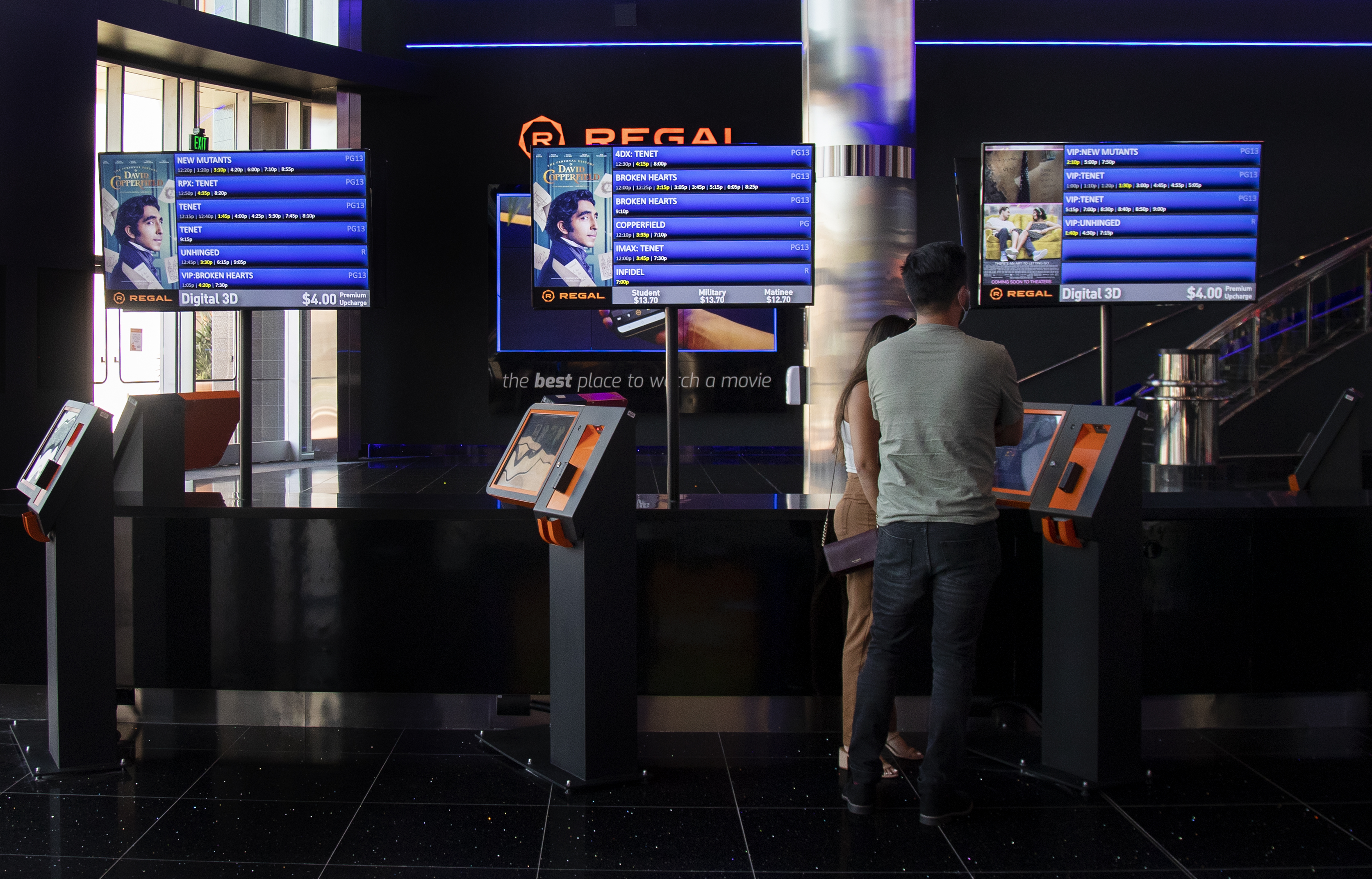 Patrons looking at upcoming showtimes at a Regal cinema