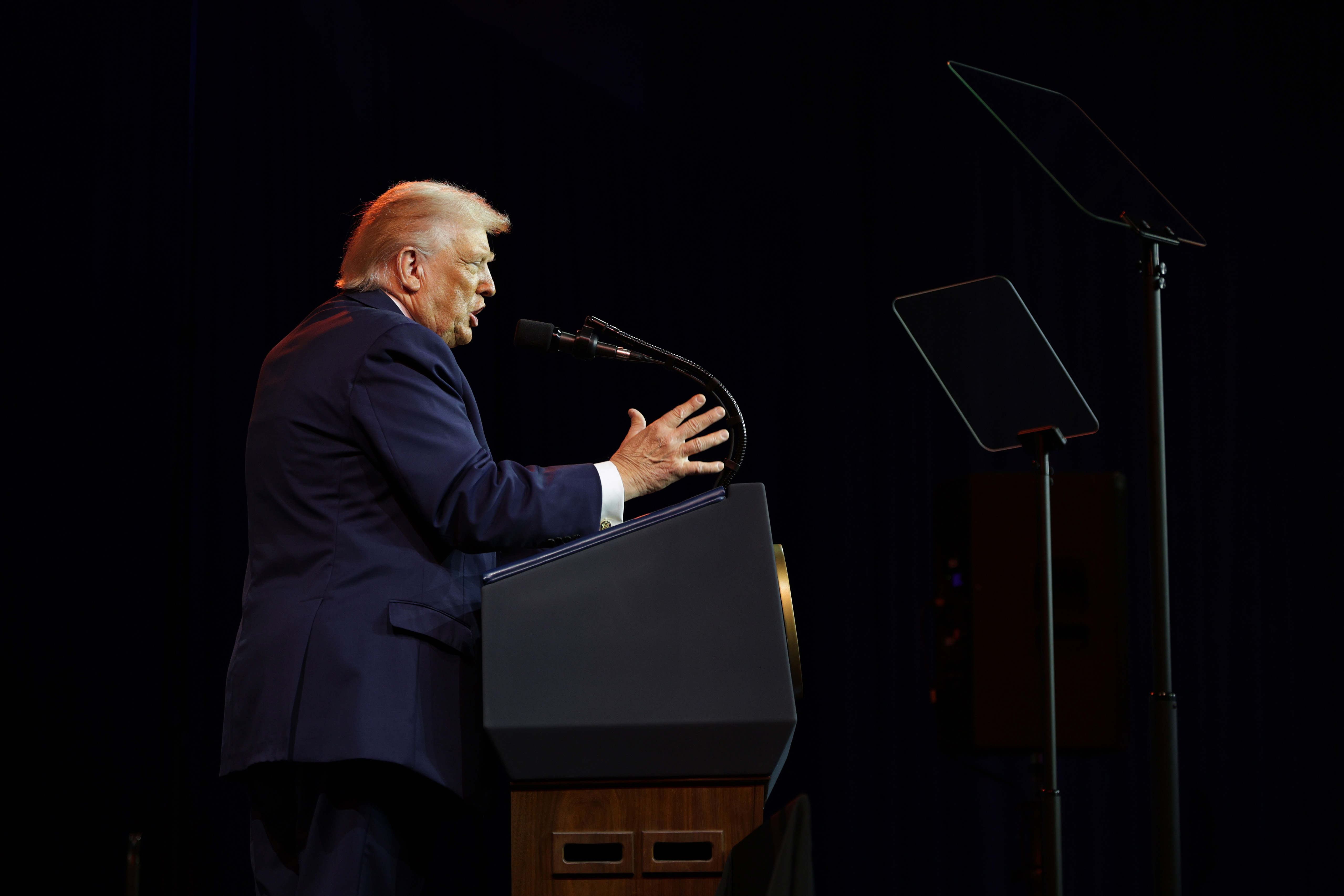 Donald Trump gestures at a podium.