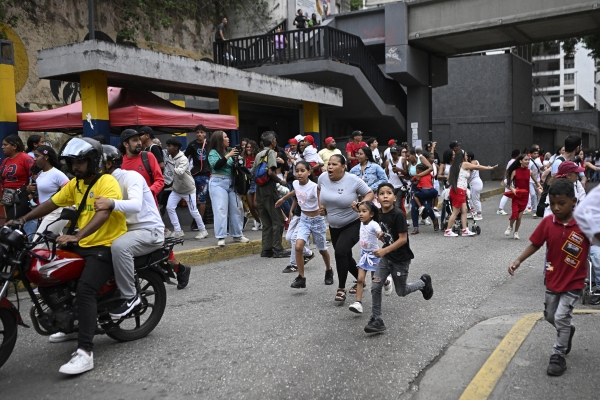  People run into a street following an earthquake in Caracas.