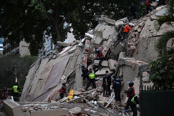Rescuers search for victims in a collapsed building following an earthquake in Caracas on June 24, 2026. 