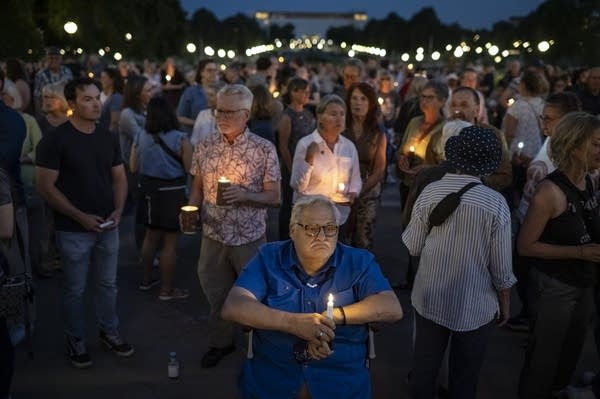 people gather with candles 