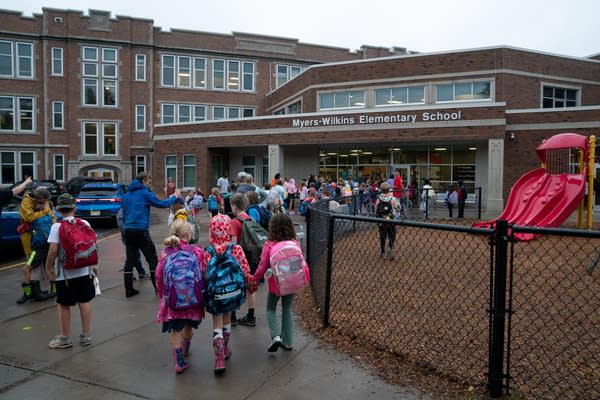 Students hold hands and walk into school 