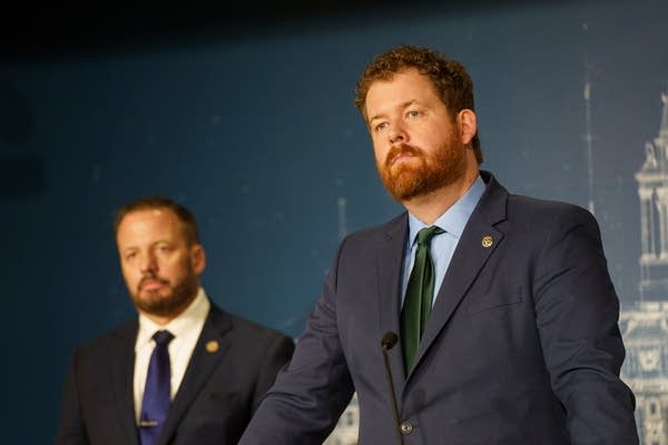 A man looks at a crowd at a podium
