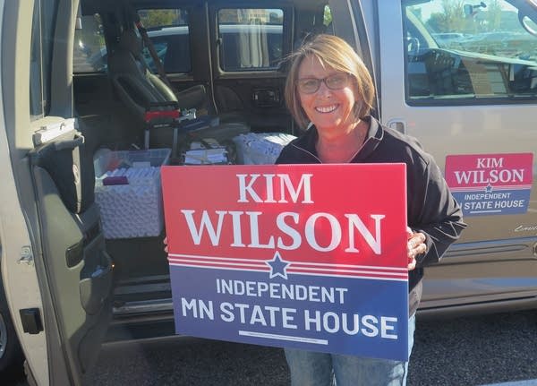 A woman holds a sign