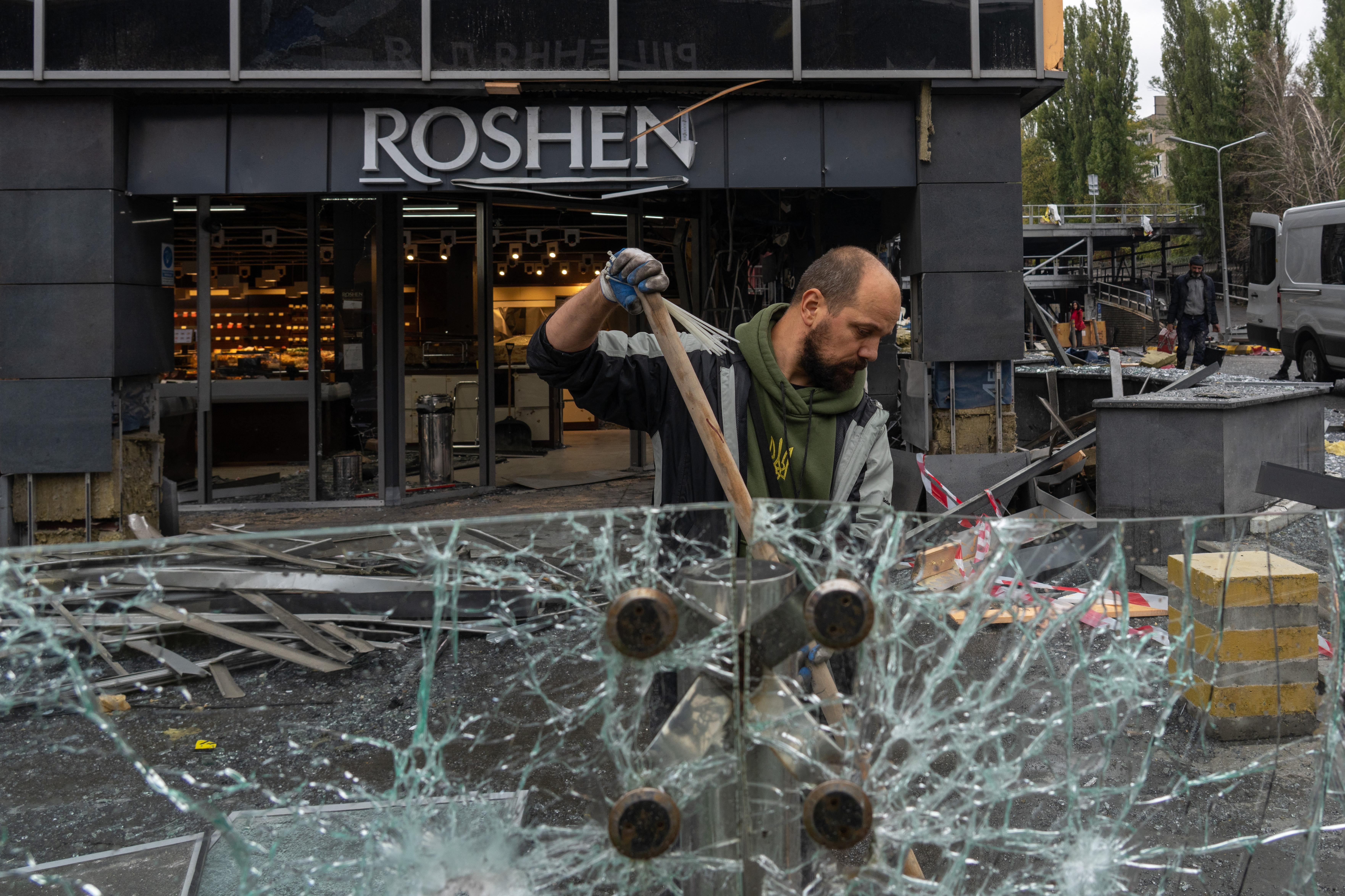 A man clears debris at the site of an air attack in Kyiv 