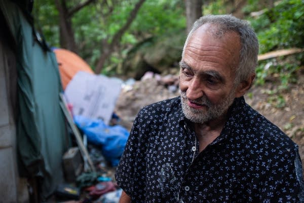 A man stands outside a tent