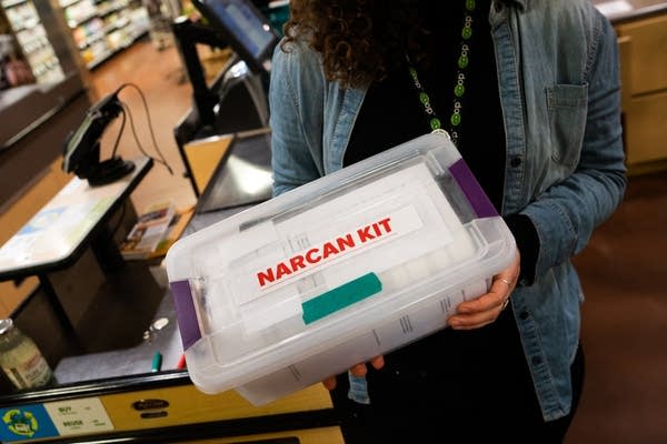 A woman holds a box that reads 