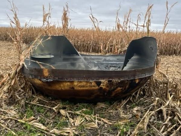 a large metal object in a corn field 