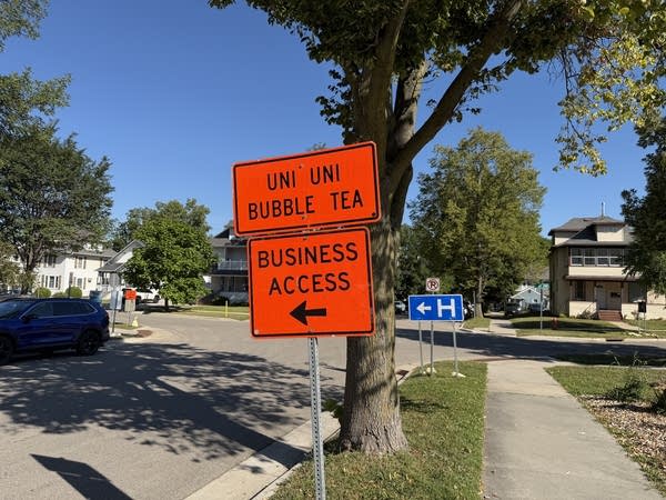 An orange construction sign reads 