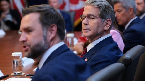 Scott Bessent sitting next to JD Vance at a table with others