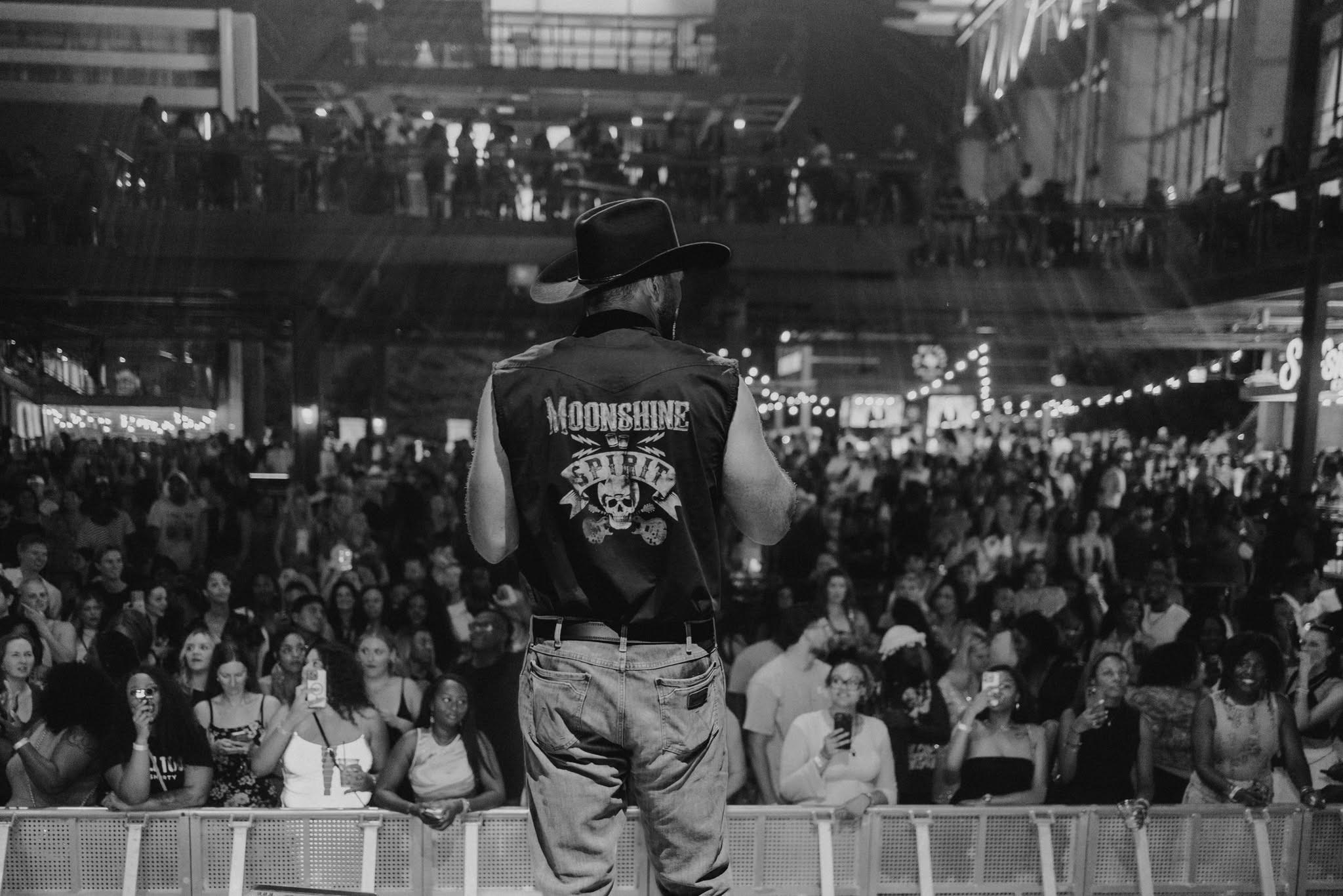 Man onstage looks over crowd