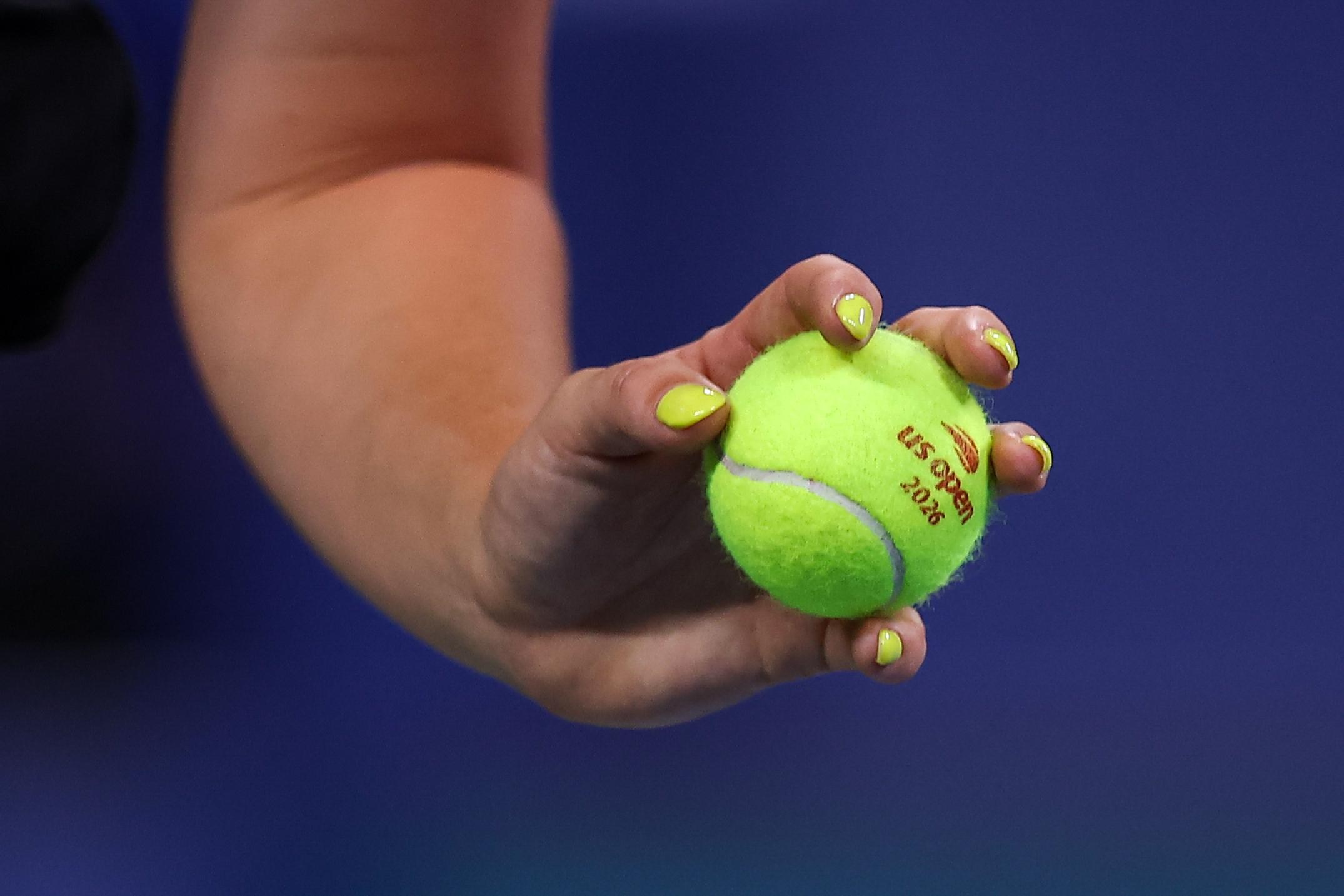 a photo of a hand holding a tennis ball