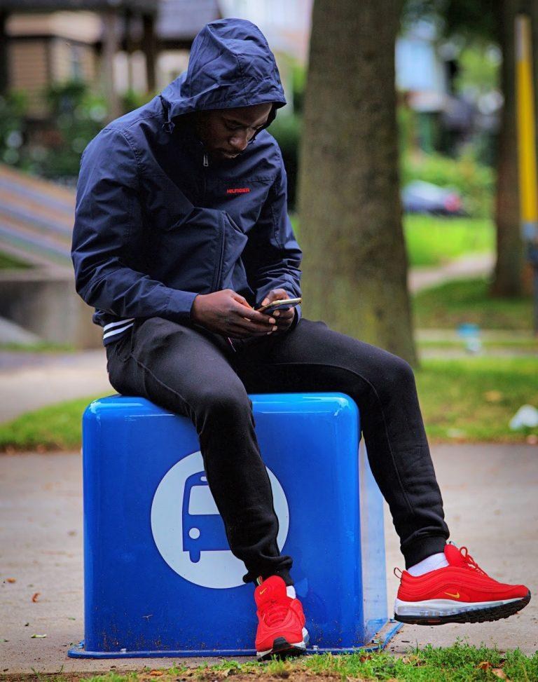 Someone sitting on a bus stop cube in Rochester
