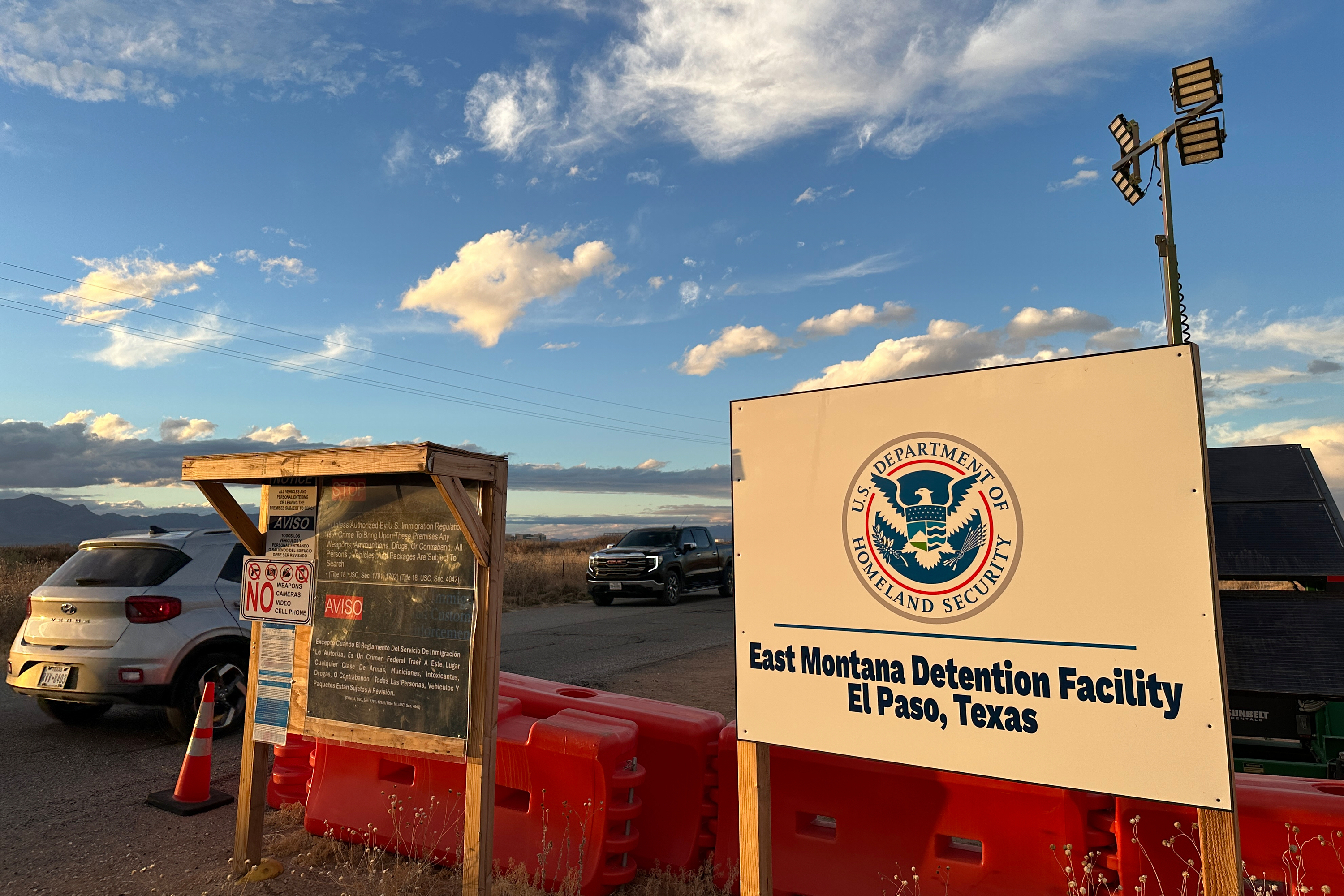 Cars drive past a sign that reads East Montana Detention Facility, El Paso, Texas.